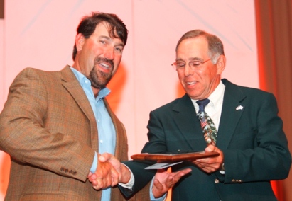 Man on stage receiving award